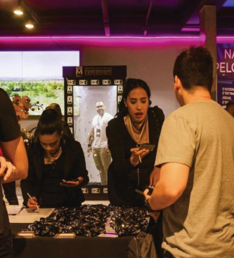 Pessoas em um evento sendo atendidas em balcão de credenciamento