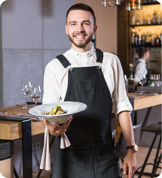 Garçom sorrindo e servindo prato